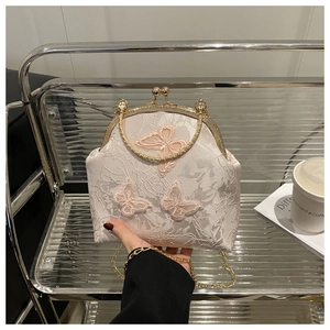 Detail of pink lace tote bag featuring 3D butterfly embroidery and gold metal clasp