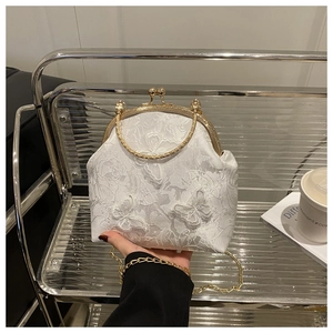 Close-up of white lace handbag featuring 3D butterfly appliqué and golden metal clasp