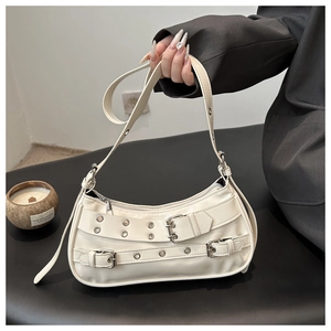 Detail van gebroken witte schoudertas met metalen oogjesbanden en zilveren gespen