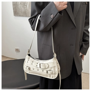 Detailopname van een witte halvemaantas met zilveren studs en een trendy Y2K-stijl