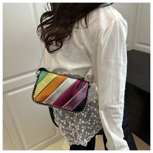 Detail of colorful metallic striped crossbody bag with silver chain strap on model