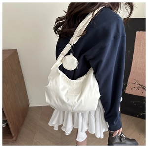 Close-up of a white Oxford cloth crescent tote bag with round coin purse and FANYISSA label