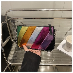 Close-up of rainbow stripe crossbody bag with silver studs and metal chain strap