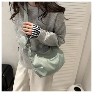 Detail of mint green nylon crescent bag with detachable round coin purse and logo patch
