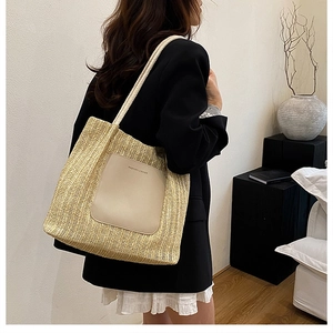 Detail of straw tote bag showing brown leather patch with FASHION & BAGS logo and rope straps