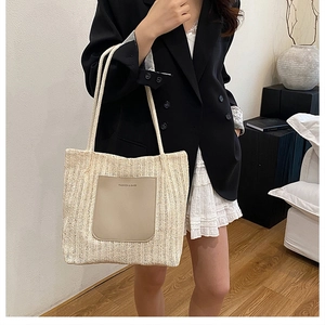 Détail du sac cabas en paille tissée avec écusson en cuir Fashion & Bags et longue bandoulière