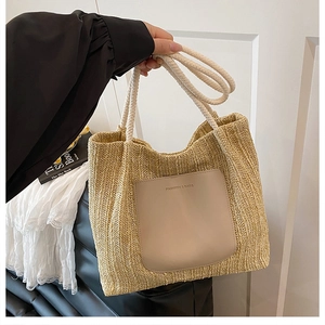 Détail du sac cabas en paille avec poche en cuir beige et anses en corde de coton