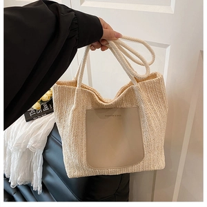 Détail d'un sac cabas en paille avec poche en cuir et texte minimaliste chic