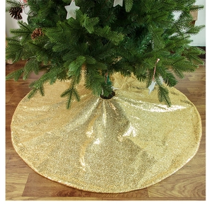 Dettaglio del tappeto per albero di Natale con paillettes dorate su pavimento in legno