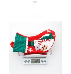 Detail shot of a red knitted Christmas stocking with embroidery weighing 42.1g on a scale