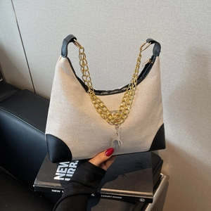 Minimalist canvas tote bag with woven texture, black leather trim and metal chain strap