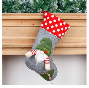 Detail of grey and red Christmas gnome stocking hanging on a wooden fireplace mantle
