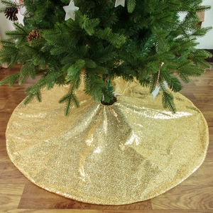 Gonna per albero di Natale con paillettes dorate scintillanti su fondo in legno