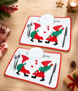 Close-up of white Christmas placemats with embroidered gnomes and red festive borders