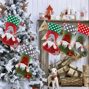 Christmas gnome stockings hanging on a fireplace mantel with festive holiday decor