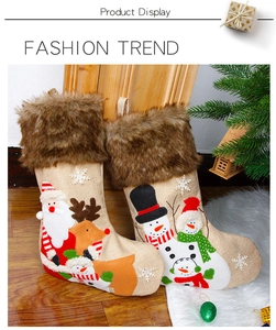 Detail of burlap Christmas stockings with Santa and reindeer embroidery on plush trim