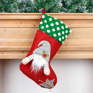 Red Christmas gnome stocking with white beard and green polka dot cuff on fireplace