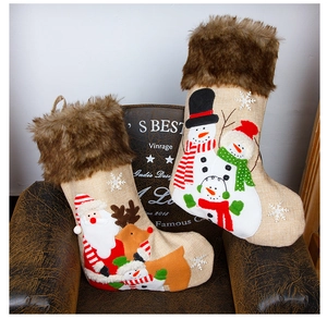 Close-up of burlap Christmas stockings with Santa and reindeer motifs on a vintage chair