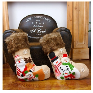 Detailed applique embroidery of Santa and reindeer on burlap Christmas stockings