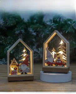 Detail of light-up wooden Christmas house ornament with warm LED lights and gnome decor