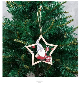 Star-shaped wooden Christmas ornament with painted gnome hanging on a pine tree branch
