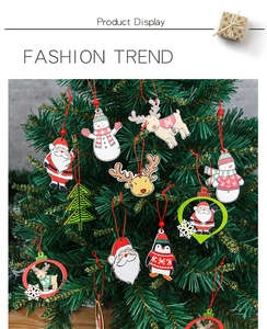 Close-up of wooden Christmas ornaments featuring Santa and reindeer hanging on a tree