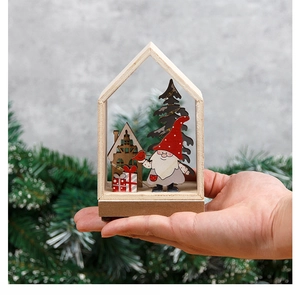 Close-up of a handcrafted wooden Christmas house ornament with warm LED lights