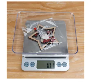Detailed view of lightweight hollow wooden star ornament being weighed at 10.1 grams