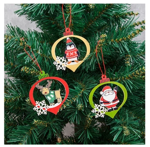 Detail of wooden Christmas pendants featuring Santa, penguin and elk on a tree branch