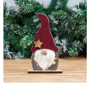 Detail of a lighted Christmas gnome ornament with red felt hat and wooden star cutout
