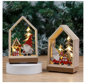 Close-up of LED glowing wooden Christmas house with gnome and festive decor