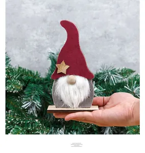 Detail of a lighted Christmas gnome ornament with red felt hat and wooden star on base