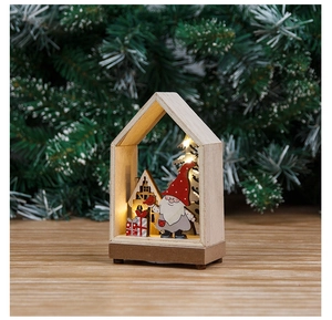 Close-up of wooden Christmas gnome house with warm LED lighting and miniature pine tree