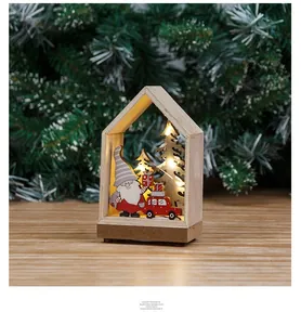 Close-up of lighted wooden Christmas house ornament with warm LED and Santa miniature