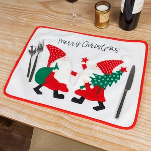 White embroidered Christmas table mat with gnomes and Merry Christmas lettering