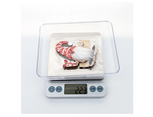 Detailed view of wooden Christmas gnome ornament on scale weighing approximately 22.3g