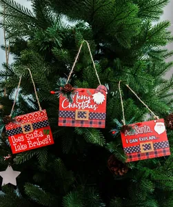 Detail of wooden Merry Christmas signs with pine needles and berries on a tree