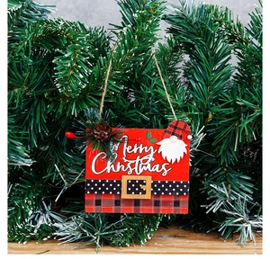 Detail of wooden Merry Christmas hanging sign with gnome and pine cones on pine tree