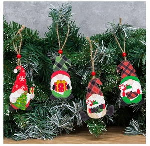 Detail of wooden gnome ornaments with rustic twine hanging on green Christmas tree branches