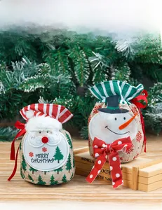 Detail of Christmas burlap gift bags featuring Santa and snowman with red polka dot bows