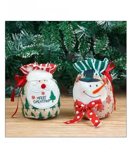 Close-up of burlap Christmas gift bags featuring cartoon Santa and snowman decorations