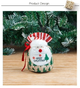 Detail of burlap Christmas gift bag with Santa face and Merry Christmas embroidery