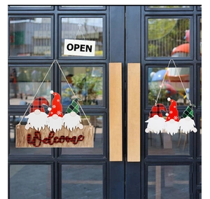 Detail of wooden Christmas Welcome sign with three cute faceless gnomes and buffalo plaid