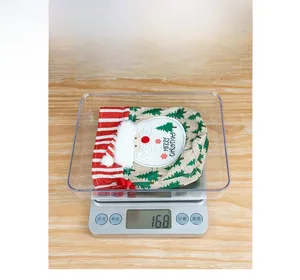 Detailed weight measurement of a Christmas linen gift bag showing 16.8g on a digital scale