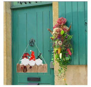Close-up of wooden Christmas welcome sign with three gnomes on a green vintage door