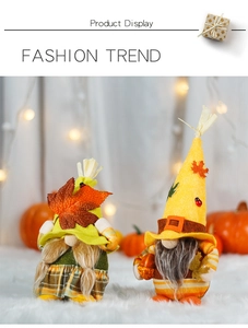 Detail of harvest gnomes with maple leaf and acorn decorations on white plush rug