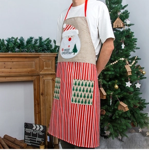 Detail of Christmas apron with Santa print, red striped pockets and linen texture