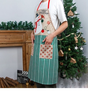 Detailed view of Christmas apron with snowman print and green stripes on a festive background