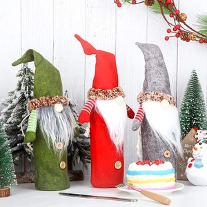 Close-up of three festive Christmas gnome wine bottle covers in red, green, and gray colors