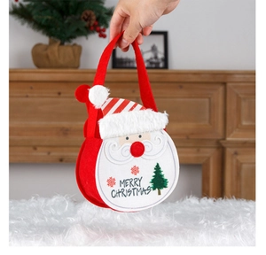 Detail of red felt Santa gift bag with Merry Christmas embroidery and fuzzy white trim